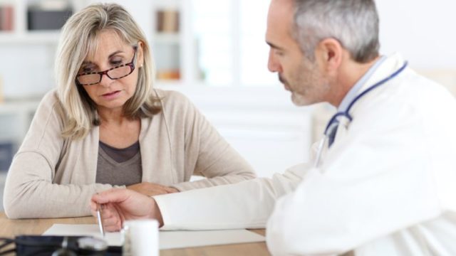 Doctor giving medicine to senior woman for arthritis pain
