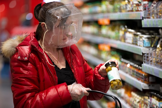 Coronovirus protection. Woman in a store with a plastic box on her face. A funny way to protect against COVID 19.Coronavirus and panic buying concept